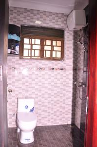 a bathroom with a toilet and a window at Seguku Katale Apartment 1 in Katale