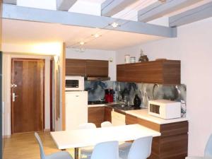 kuchnia ze stołem, krzesłami i kuchenką mikrofalową w obiekcie Appartement Les Chaumettes w mieście Orcières