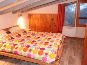 - une chambre avec un grand lit et une couette colorée dans l'établissement Appartement Les Chaumettes, à Orcières