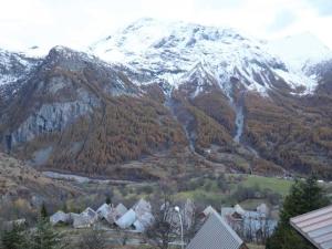 a snow covered mountain with houses in front of a town w obiekcie Appartement Les Chaumettes w mieście Orcières