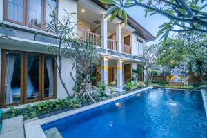 a villa with a swimming pool in front of a house at Ubud Tropical Garden 2 in Ubud