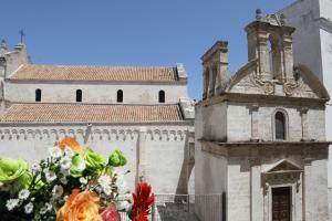eine Vase voller Blumen vor einer Kirche in der Unterkunft DIMORA AMALFITANA in Monopoli