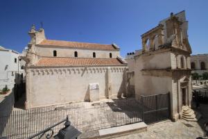 ein Gebäude mit einem Tor davor in der Unterkunft DIMORA AMALFITANA in Monopoli