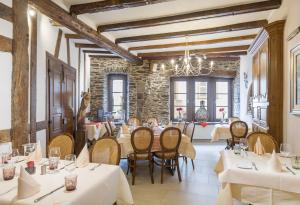 een restaurant met tafels en stoelen en een stenen muur bij Hotel Petry in Vianden