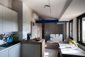 een keuken met witte kasten en een eetkamer bij Debbie's House in Desenzano del Garda