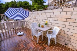 Villa Pinus في سومارتين: طاولة وكراسي مع مظلة على الفناء
