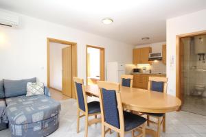 a kitchen and dining room with a table and chairs at Apartments Mikulan Nara in Baška