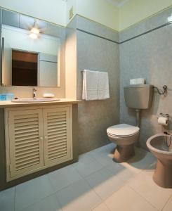 uma casa de banho com um WC, um lavatório e um espelho. em RR Club Amarilis em Portimão