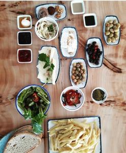 una mesa de madera con platos de comida. en Eleia Hotel İznik, en Bursa