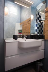 Un baño con un lavabo blanco y un espejo. en Debbie's House, en Desenzano del Garda