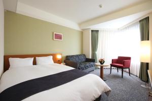 a hotel room with a bed and a chair at Kyoto Garden Palace in Kyoto