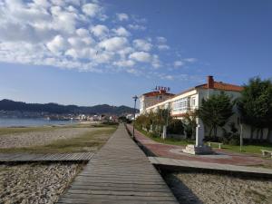 a boardwalk next to a building on a beach at Hotel Playa in Cangas de Morrazo