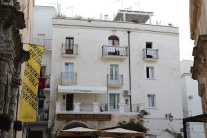 ein weißes Gebäude mit einem Schild für ein Hotel in der Unterkunft DIMORA AMALFITANA in Monopoli + 9 Fotos