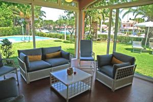 una veranda riparata con sedie e tavolino di Portorosa Residence a Furnari