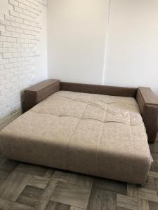 uma cama num quarto com uma parede de tijolos em Lux Apart Torfyana em Lviv