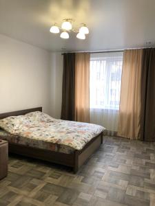 um quarto com uma cama e uma janela em Lux Apart Torfyana em Lviv