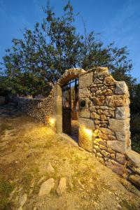 ein Steinhaus mit einer Tür in einer Steinmauer in der Unterkunft Citta dei Nicliani in Koíta