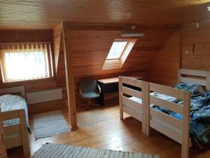 1 dormitorio con 2 camas y un escritorio en una cabaña en Pähni külalistemaja, en Rõuge