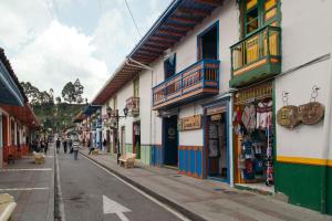 a street with buildings and people walking down the street at Hostal La Casa De Lili in Salento