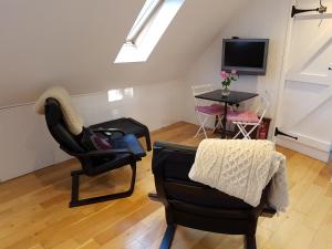 a living room with two chairs and a tv at Wellrose Barn in Hertford