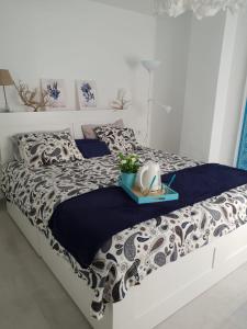 a white bed with a black and white comforter at Las Princesas in El Médano