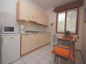 eine Küche mit einem weißen Kühlschrank und einem Tisch in der Unterkunft Villa Tiziano in Lignano Sabbiadoro