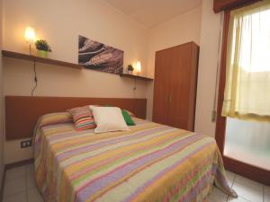 ein Schlafzimmer mit einem Bett mit einer bunten gestreiften Decke in der Unterkunft Villa Tiziano in Lignano Sabbiadoro