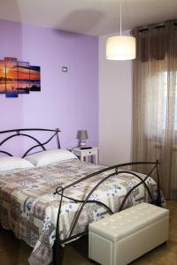 ein Schlafzimmer mit einem Bett und einer lila Wand in der Unterkunft Dimora Pompeiana in Pompei