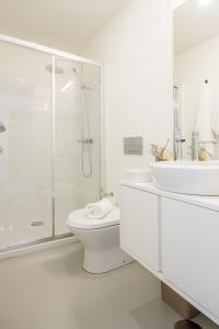 a white bathroom with a shower and a toilet and a sink at Oporto Sweet Home I in Porto