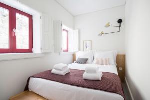 ポルトにあるOporto Sweet Home Iの白いベッドルーム(ベッド2台、窓2つ付)が備わります。