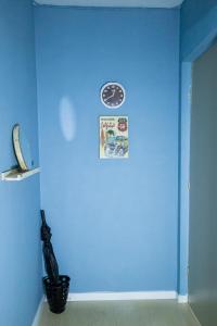 a blue room with a clock on a wall at Meu lugar na Cidade Baixa in Porto Alegre