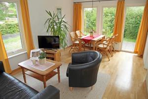 a living room with a table and chairs at Ferienwohnungen an den Salzwiesen in Boltenhagen