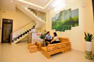 three women sitting in a living room with a staircase at Guest House Maika in Hue