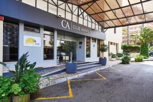 a store front with potted plants in front of it at RR Club Amarilis in Portimão