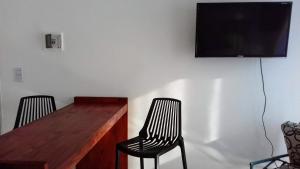 two chairs sitting next to a desk with a television on a wall at El Balcón 2 in Concepción del Uruguay