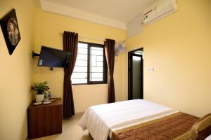 a bedroom with a bed and a flat screen tv at Guest House Maika in Hue