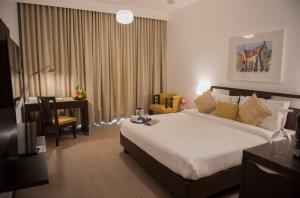 a hotel room with a large bed and a desk at Hotel Sunderban Resort & Spa in Pune