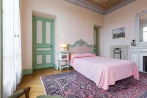 a bedroom with a pink bed and a fireplace at Résidence La Villa Léonie in Nice