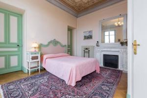 a bedroom with a pink bed and a fireplace at Résidence La Villa Léonie in Nice