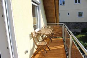 een veranda met een houten tafel en stoelen op een balkon bij Ferienwohnung in der Natur in Drolshagen
