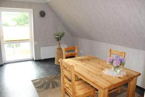 een eetkamer met een houten tafel met bloemen erop bij Ferienwohnung in der Natur in Drolshagen