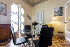 a dining room with a glass table and black chairs at Résidence La Villa Léonie in Nice