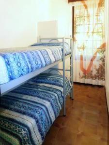 two bunk beds in a room with a tile floor at Tra i Pini in Lignano Sabbiadoro