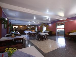 um restaurante com mesas e cadeiras e paredes roxas em Pousada Vale da Montanha em Serra Negra