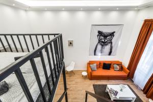 Hello Downtown Apartment - Boulevard في بودابست: غرفة معيشة مع أريكة برتقالية ولوحة