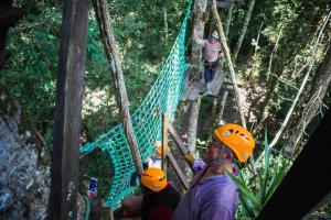 a group of people on a suspension bridge in the jungle at Avatar Amazon Lodge & Canopy Park in Santa Teresa