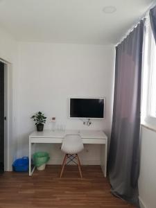 a desk with a television and a chair in a room at Republica83-Campo Pequeno Home in Lisbon