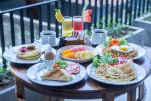 a table with plates of breakfast food on it at Darba Guest House Ubud in Ubud