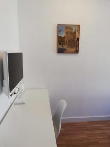 a white desk with a computer and a picture on the wall at Republica83-Campo Pequeno Home in Lisbon