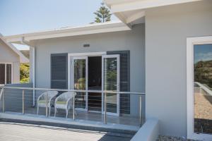 a house with two chairs on a balcony at The Whale on Main B&B in Hermanus
